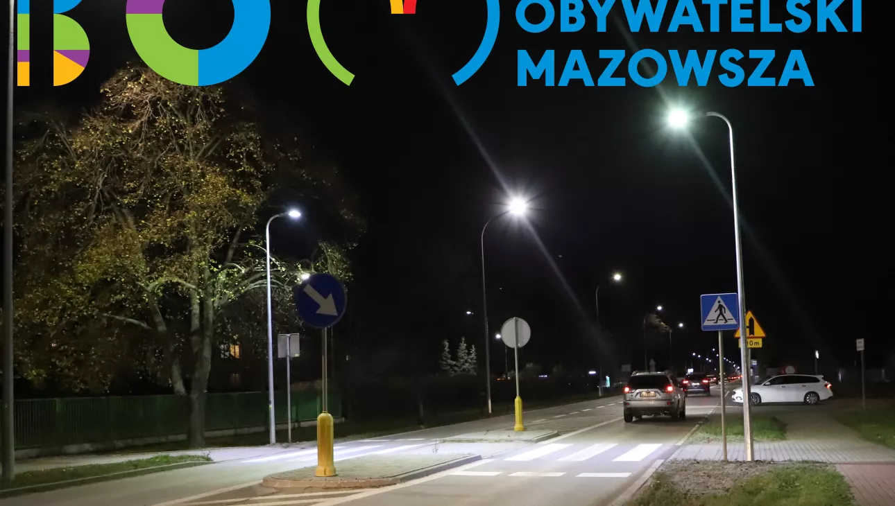 Zdjęcie przedstawia oświetlone przejście dla pieszych z logotypem Budżetu Obywatelskiego Mazowsza