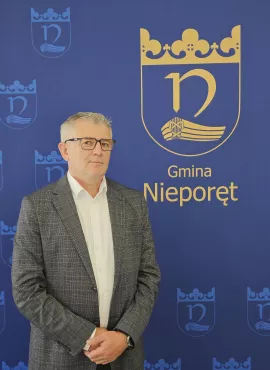 Na zdjęciu Sławomir Wierzchoń, na tle granatowej ścianki promocyjnej Gminy Nieporęt