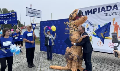 Olimpiada Seniorów Nieporęt 2026 - na zdjęciu reprezentacja gminy Nieporęt z maskotką - dinozaurem